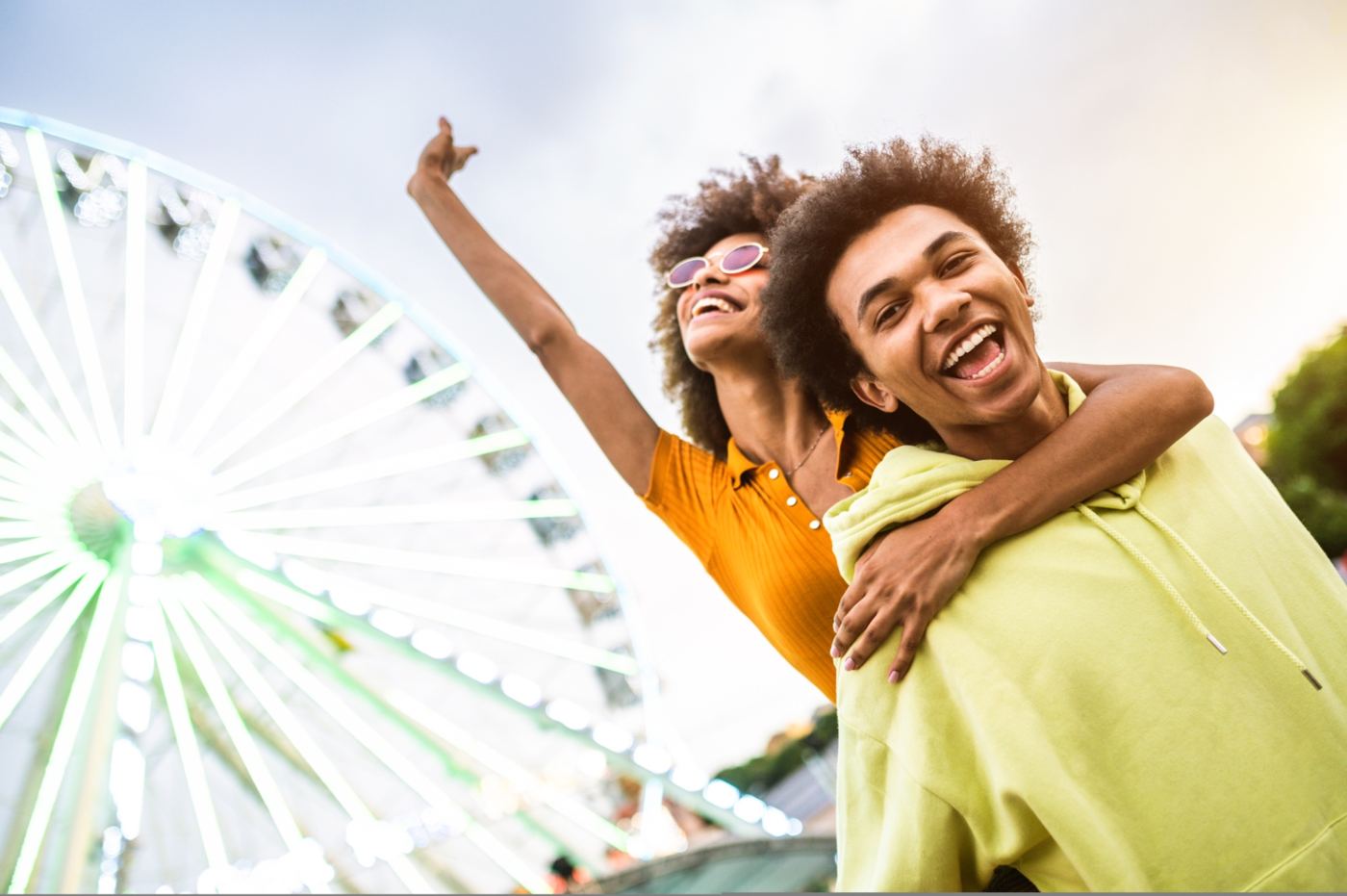Two people laughing together at a funfair on a Veya date
